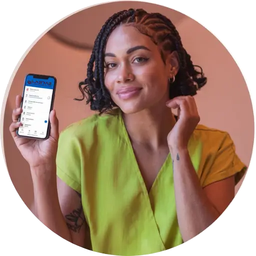 Uma mulher sorridente, de pele morena e cabelo curto com tranças, segurando um smartphone que exibe o aplicativo "Labraz" em sua tela. Ela está vestida com uma blusa verde e tem tatuagens visíveis no braço. A mulher olha diretamente para a câmera com uma expressão amigável, enquanto segura o celular de forma que a tela seja claramente visível, destacando o uso de tecnologia para acesso a serviços laboratoriais. O fundo da imagem é suave, realçando a figura da mulher e o aparelho que ela apresenta.